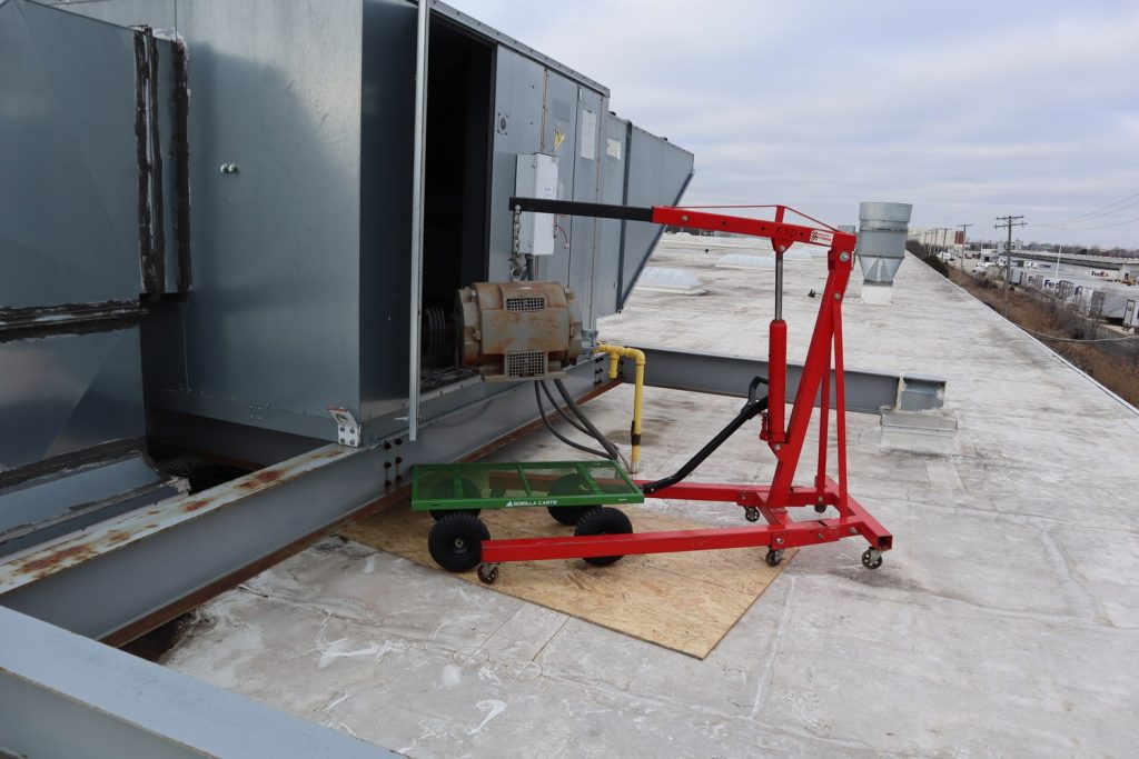 telehandler lifting motor into spray booth extractor
